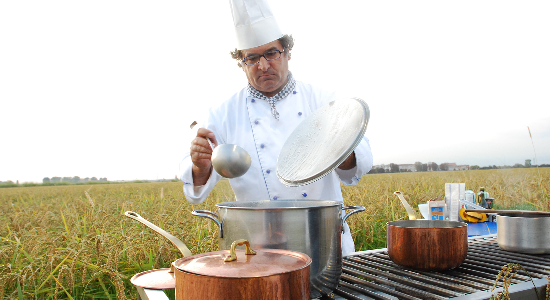 Gabriele Ferron in divisa da chef mentre prepara un risotto